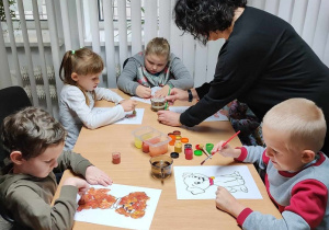 Pani Ewa pomaga dzieciom w tworzeniu prac
