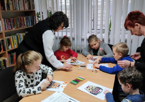 Dzieci wykonują pracę plastyczną z pomocą p. Ewy