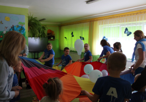 Zabawa z chustą animacyjną - na zdjęciu wszyscy uczestnicy zajęcia