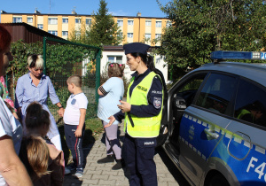 Pogadanka przy radiowozie policyjnym na temat bezpieczeństwa - na zdjęciu uczestnicy zajęcia