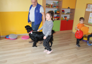 Marcowe zajęcia z dogoterapii - na zdjęciu Julia prowadza psa na smyczy