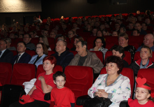 Obchody Światowego Dnia Osób z Zespołem Downa w MDK - na zdjęciu Ania i Kubuś z Panią dyrektor i Panią Anią, w tle pozostali uczestnicy obchodów
