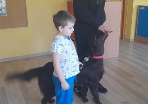 Zajęcia z dogoterapii - na zdjęciu Yaroslav z terapeutką spacerują z psem.