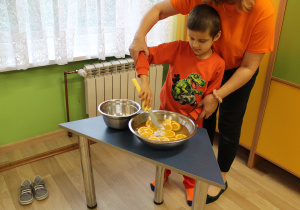 Dzień pomarańczowy - na zdjęciu Ksawery łowi plastry pomarańczy