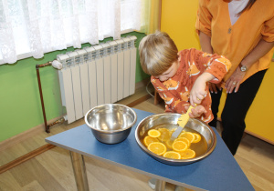 Dzień pomarańczowy - na zdjęciu Mikołaj łowi plastry pomarańczy