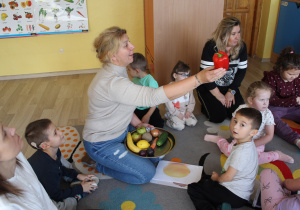 Tydzień higieny - na zdjęciu przedszkolaki i p. Agnieszka oglądają owoce i warzywa
