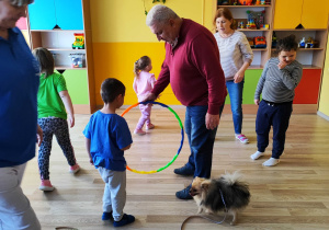 Zajęcia z dogoterapii - dzieci bawią się z psami i z obręczą
