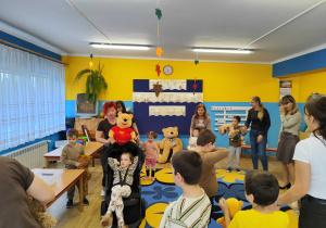 Dzieci tańczą w kole z misiami.