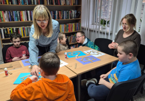 Grudniowe spotkanie czytelnicze - na zdjęciu przedszkolaki w trakcie wykonywania pracy plastycznej