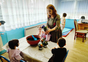 Dzieci z p. Ulą przesadzają kwiatki