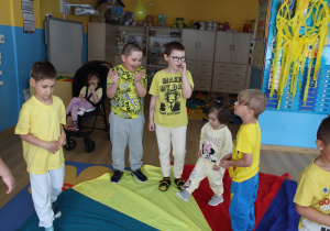 Żółty dzień w przedszkolu - przedszkolaki podczas zabawy z chustą animacyjną