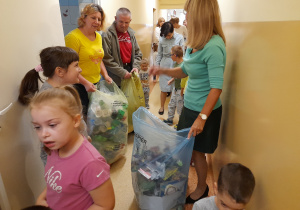 Dzieci i pracownicy przedszkola porządkują korytarz. Na zdjęciu Hana, Lena z panią Kasią i panią Agnieszką.