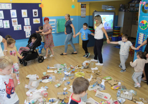 Sprzątanie świata - dzieci tańczą wokół rozrzuconych śmieci.