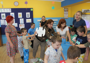 Sprzątanie świata - Chłopcy wrzucają papier do niebieskiego worka.