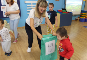 Sprzątanie świata - Antoś wrzuca szklany słoik do zielonego worka.
