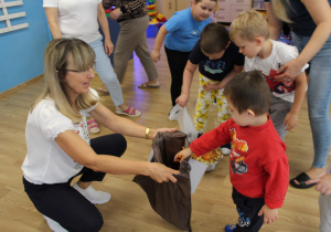 Sprzątanie świata - Antoś wyrzuca obierki z marchewki do brązowego worka.
