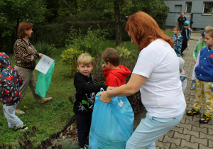 Sprzątanie świata - dzieci sprzątają teren wokół przedszkola