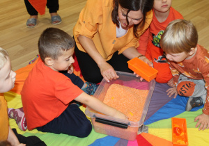 Dzień pomarańczowy - na zdjęciu Wiktor poszukuje skarbów w pomarańczowym ryżu