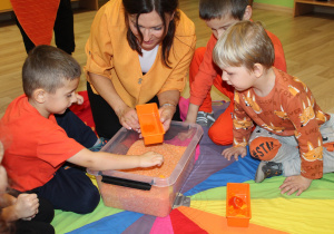Dzień pomarańczowy - na zdjęciu przedszkolaki poszukują skarbów w pomarańczowym ryżu