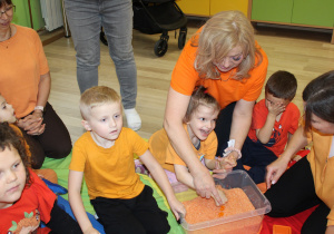 Dzień pomarańczowy - na zdjęciu Nadia poszukuje skarbów w pomarańczowym ryżu