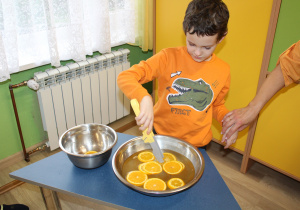 Dzień pomarańczowy - na zdjęciu Kuba łowi plastry pomarańczy