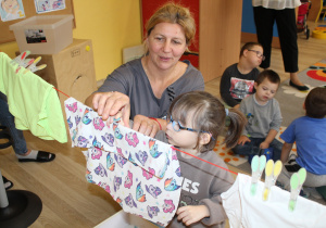 Tydzień higieny - na zdjęciu Marysia z pomocą p. Agnieszki rozwiesza "pranie"