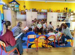 dzieci siedzą z Paniami w kole.