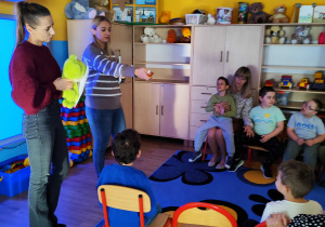 Panie prezentują dzieciom żabę Ferdka i muchy