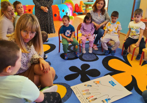 Dzieci z Paniami tworzą plakat "Pomocna dłoń"