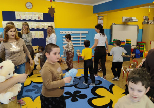 Dzieci tańczą w kole z misiami.