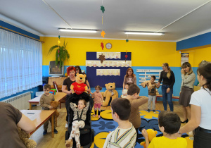 Dzieci tańczą w kole z misiami.