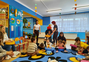 Dzieci z Paniami wystukują rytm do piosenki.