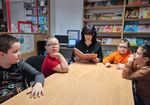 Chłopcy słuchają bajki czytanej przez p. Ewę.