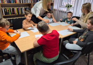 Chłopcy wykonują pracę plastyczną.