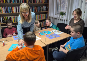 Grudniowe spotkanie czytelnicze - na zdjęciu przedszkolaki w trakcie wykonywania pracy plastycznej