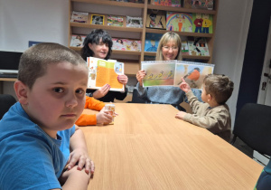 Grudniowe spotkanie czytelnicze - na zdjęciu przedszkolaki słuchają opowiadania i oglądają ilustracje ptaków