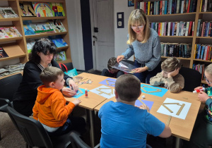 Grudniowe spotkanie czytelnicze - na zdjęciu przedszkolaki w trakcie wykonywania pracy plastycznej