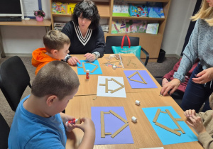Grudniowe spotkanie czytelnicze - na zdjęciu przedszkolaki w trakcie wykonywania pracy plastycznej