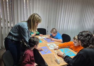 Grudniowe spotkanie czytelnicze - na zdjęciu przedszkolaki w trakcie wykonywania pracy plastycznej