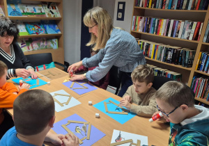 Grudniowe spotkanie czytelnicze - na zdjęciu przedszkolaki w trakcie wykonywania pracy plastycznej