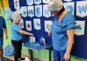 Dzień niebieski - Mikołaj miesza niebieską farbę w słoiku z wodą.