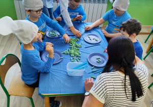 Dzień niebieski - dzieci z grupy I łapią makaronowe rybki na słomki.