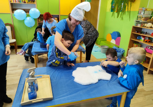 Dzień niebieski - dzieci z grupy IV kolorują chmurki spryskiwaczem z niebieską farbą.