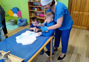 Dzień niebieski - Antoś z Filipem kolorują chmurki spryskiwaczem z niebieską farbą.