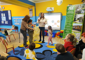 Krzysiu wrzuca plastikową butelkę do żółtego worka.