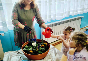 Dzieci podlewają kwiatki