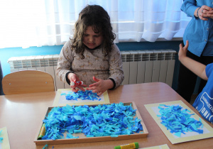 Przedszkolne obchody Dni Autyzmu - na zdjęciu Julia tworzy pracę plastyczną