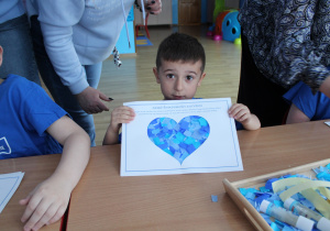 Przedszkolne obchody Dni Autyzmu - na zdjęciu Wiktor prezentuje swoje ,,niebieskie serduszko"
