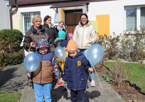 Przedszkolne obchody Dni Autyzmu - na zdjęciu przedszkolaki wraz z paniami wychodzą na ,,niebieski spacer"