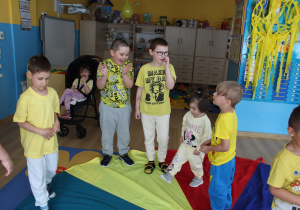 Żółty dzień w przedszkolu - przedszkolaki podczas zabawy z chustą animacyjną